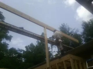 Carpenter setting a ridge beam over a new addition frame — Ice Dam Removal by Roofing Brothers in Holy Cross