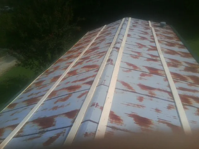 Rusted metal roof panels with new wood purlins before replacement — Storm Damage Roof Repair in Holy Cross by Roofing Brothers