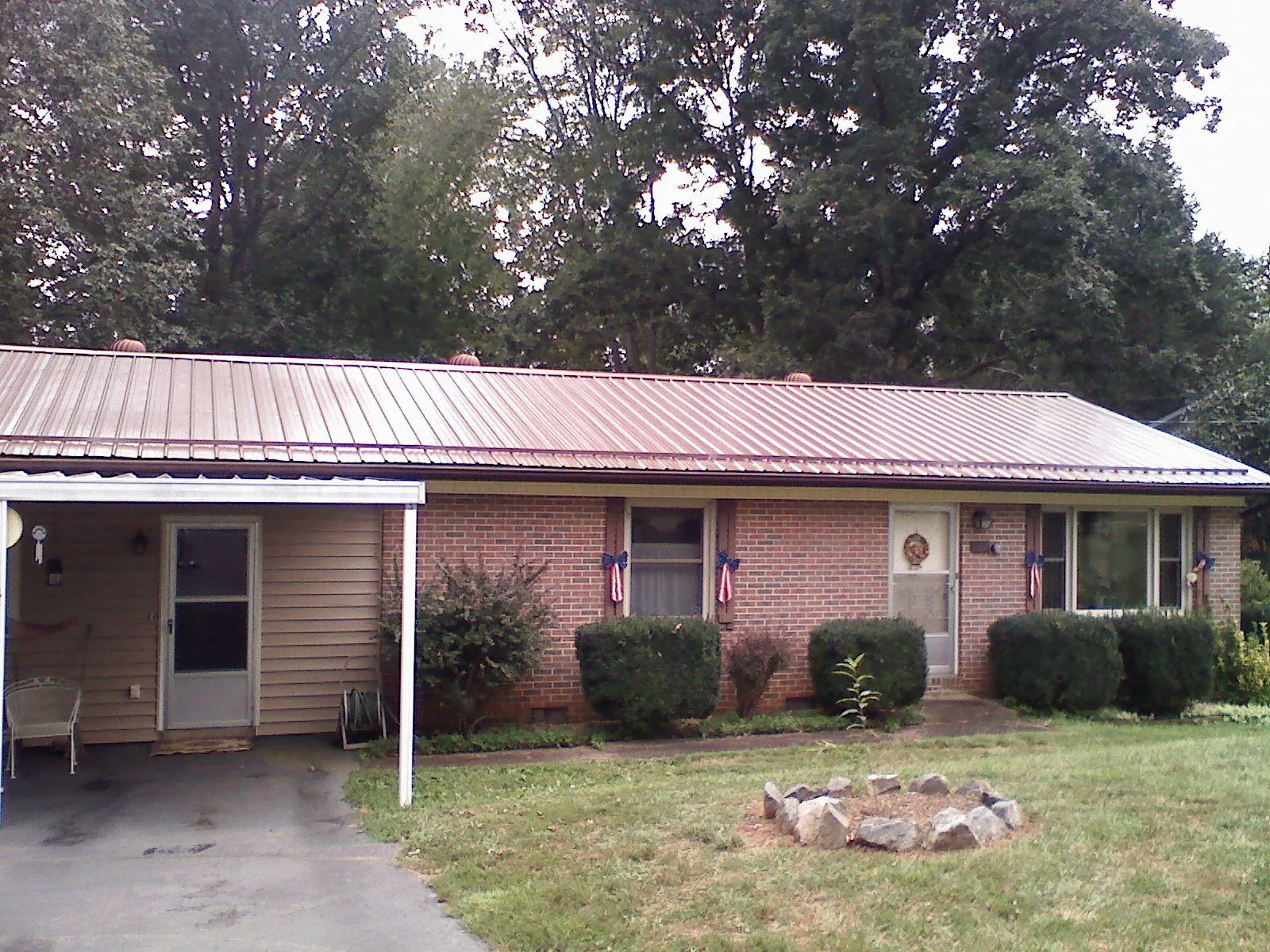Bronze metal roof and carport on a brick ranch home — Roof Repair work by our crew in Holy Cross
